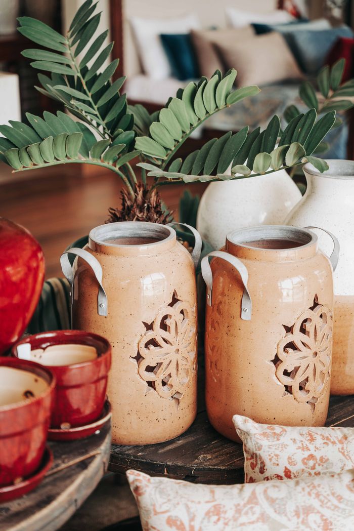 Warm and inviting rustic jars with vibrant leafy decorations in a cozy home interior setting.