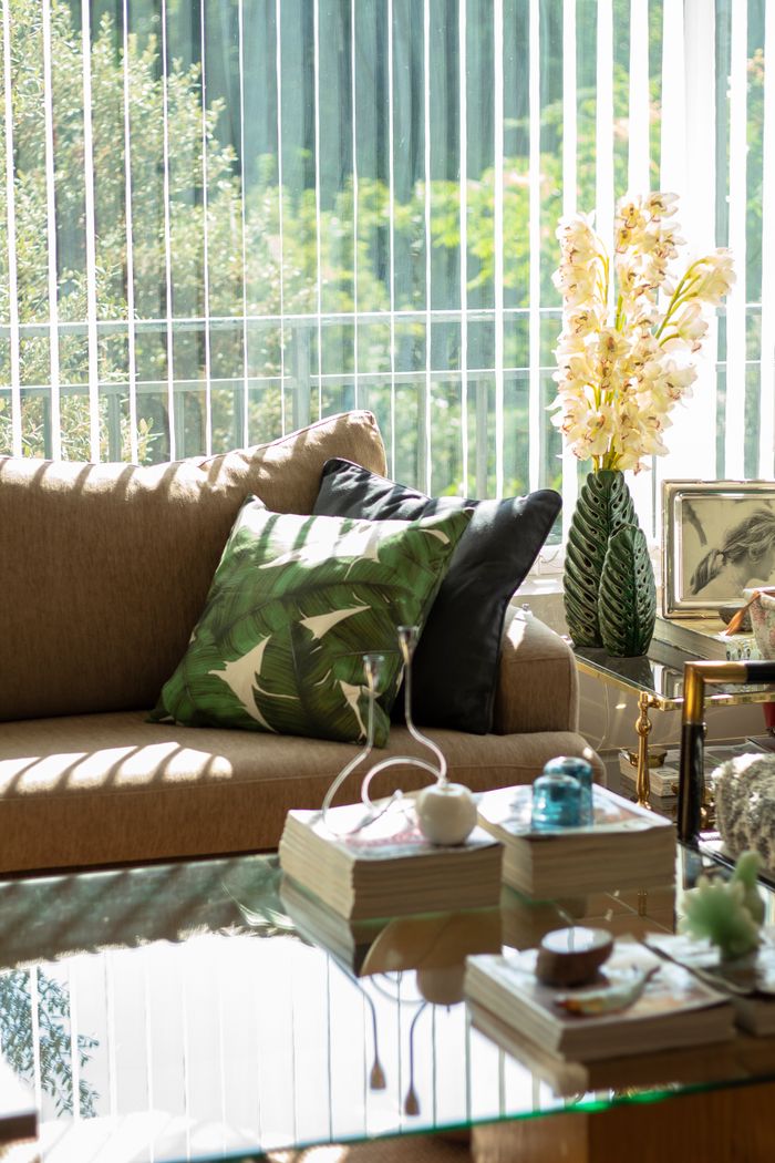 Interior of a modern living room with a glass table, stylish sofa, and decorative elements.