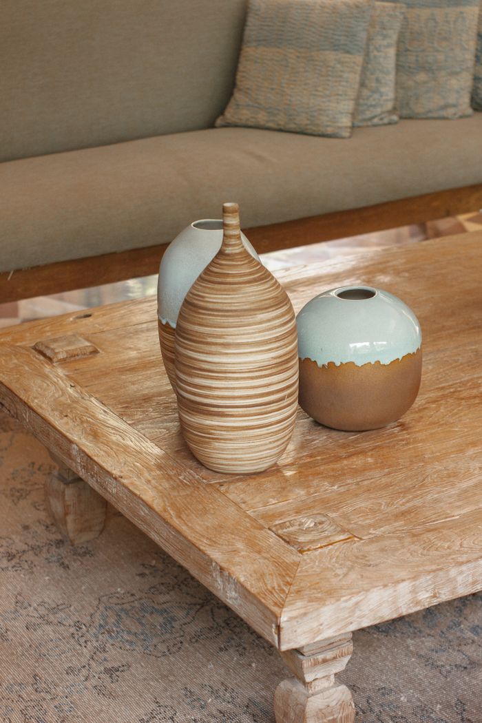 Elegant wooden coffee table with artistic ceramic vases in a cozy living room.