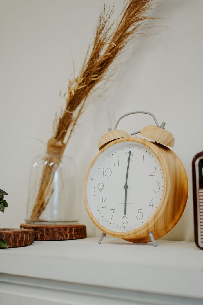 Stylish wooden alarm clock on a minimalist mantle adds rustic charm indoors.